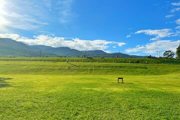 Mountain view green field with clear blue sky