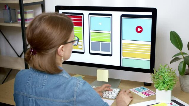 A woman UI designer creates sketches of applications for smartphones on a computer. Designing a developer's mobile phone interface.
