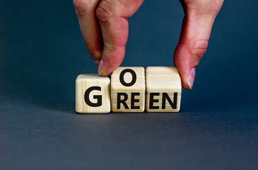 Ecology and go green symbol. Concept words Go green on wooden cubes. Businessman hand. Beautiful grey table grey background. Business ecological and go green concept. Copy space.