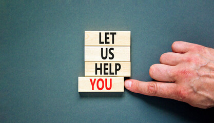 Support and let us help you symbol. Concept words Let us help you on wooden blocks on a beautiful grey table grey background. Businessman hand. Business, support and let us help you concept.