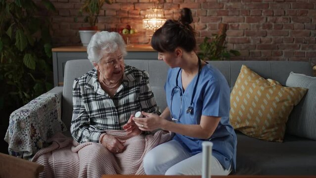 Nurse consulting medication with elderly woman at retirement home
