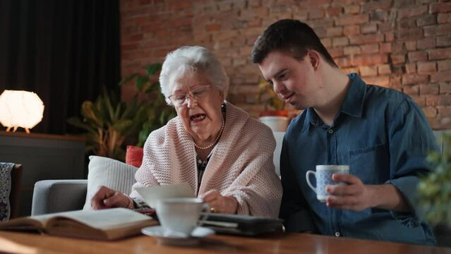 Grandmother with Down Syndrome Adult looking at photos, talking