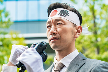 マイクを使って街頭で主張を訴える男性