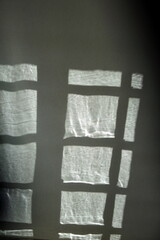 Ombre de la fenêtre sur le rideau blanc.