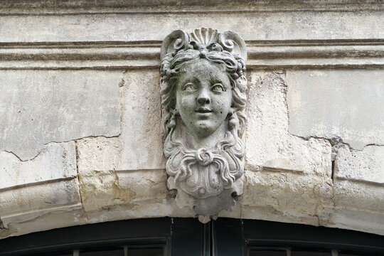 Visage de femme sculpté dans la pierre, ornement de façade d'une maison ancienne.  Paris, France