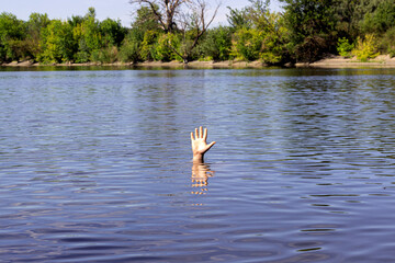 a man is drowning, his hand is sticking out of the water