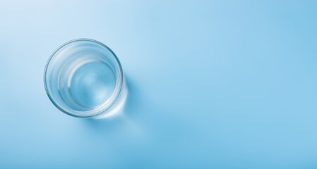 Glass of pure cold water on a blue background.