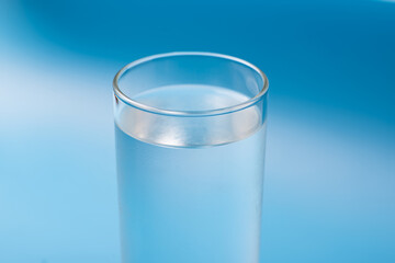Glass of pure cold water on a blue background.