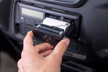 Digital tachograph with an open printer and visible roll of paper. Paper roll Replacement in a truck digital tachograph