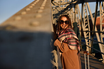 portrait of a beautiful young woman in glasses with a cheerful mood against the background of the sunset