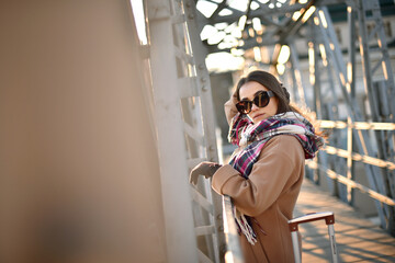 portrait of a beautiful young woman in glasses with a cheerful mood against the background of the sunset