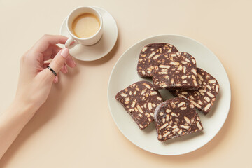 Traditional portuguese dessert Salame de Chocolate on beige background in minimal style. Homemade cocoa cake.
