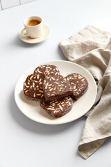Traditional portuguese dessert Salame de Chocolate on beige background in minimal style. Homemade cocoa cake.