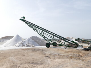Conveyor belt and mountains of salt in the salt fields of Es Trenc, Mallorca, Balearic Islands, Spain