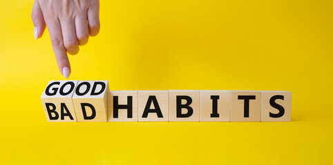 Good and bad Habits symbol. Businessman points at wooden cubes with words Bad Habits and Good Habits. Beautiful yellow background. Medicine concept. Copy space