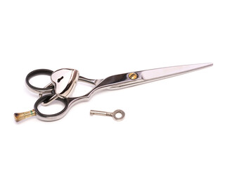 Obraz premium Hairdressing scissors are closed with a padlock and the key to it. Heart shaped lock The concept of security, safety, privacy, turnkey business in the beauty industry. Isolated on white background