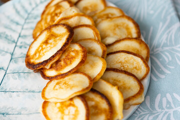 Homemade small pancakes on light blue plate