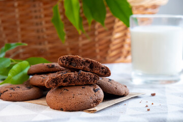 Homemade chocolate chip cookies on wooden board with glass of milk. Recipe of cookies with chocolate chips. Snack or treat in cafe or restaurant menu.