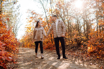 Fototapeta premium Stylish couple walking and enjoying autumn weather. People, lifestyle, relaxation and vacations concept. Autumn Fashion, style concept.
