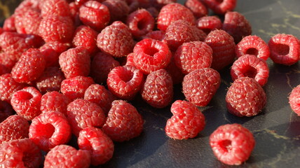 Ripe raspberries  on a dark, black background. Background composition