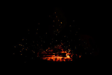 Fototapeta na wymiar Campfire flame sparks isolated on black background. Fire flames heat energy heap in the night. Fire sparkles isolated on black