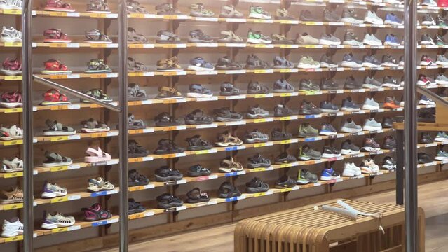 Sports shoes: sneakers and sandals stand on the shelves of a shoe store