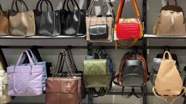 Rows of women's handbags are on the shelves of women's accessories store
