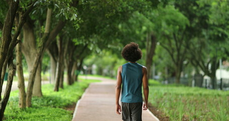 Fototapeta na wymiar Back of african black man walking at park outdoors