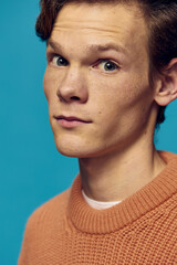 portrait of a handsome, nice guy with freckles on a blue background