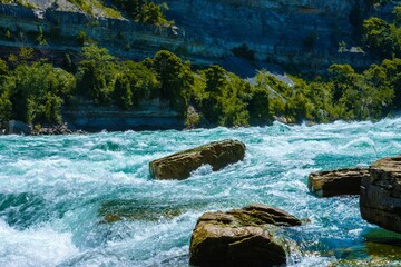 Scenic view of a blue crystal clear river with rocky shores in the Niagara Gorge