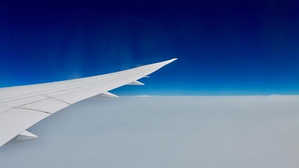 Fototapeta na wymiar 飛行機の翼と雲海と青空