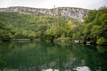 Fototapeta premium Beautiful rocky cliffs and mountain peaks, covered with dense forest near the town of Omis, Croatia in the Cetina river canyon