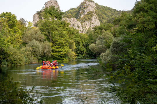 Group Of Tourists Taking Rafting Tour On The Cetina River, Listening To The Information From The Instructor In The Dinghy