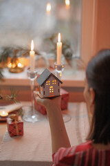 woman is holding boxes with gifts for Christmas, soft selective focus, new year or birthday. Christmas eve decoration, candles and fir branches. festive mood, seasonal sales in stores, time to shop
