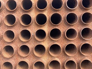 A group of arranged pipe ends of a rusted vessel