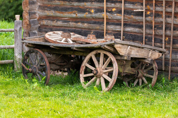 Fototapeta na wymiar Old wooden wagon stands on green grass