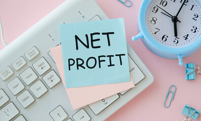 A colored sticker with the text NET PROFIT lies on the keyboard