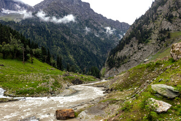 Obraz premium Beautiful mountain scenery. River, valley, snow, blue sky, white clouds. In-depth trip on the Sonamarg Hill Trek in Jammu and Kashmir, India
