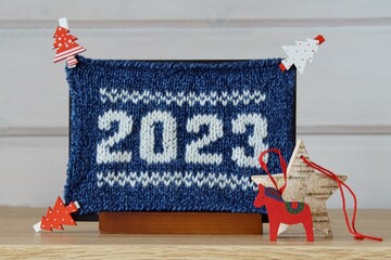Christmas card with blue and white numerals knitted from wool 2023, Swedish horse, paper clips in...