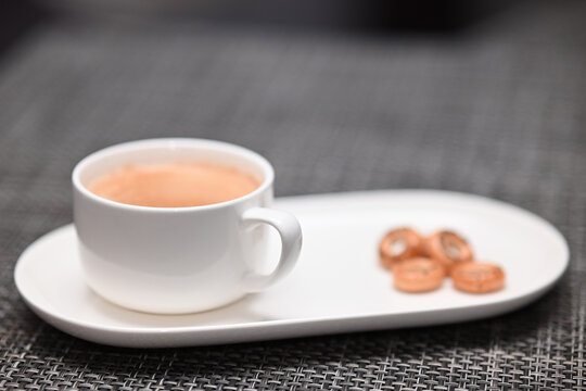 eine tasse kaffe mit kringeln auf dem design teller