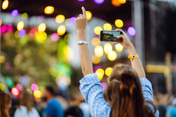 Using a smartphone in a public event, live music festival.  Summer holiday, vacation concept. 