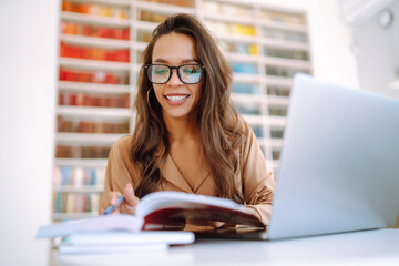 Young woman with wireless headphones calling on laptop. Online conference, training. Freelancer, business, education concept.