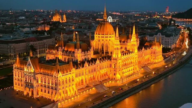 illuminated Hungarian Parliament Building with the Danube river, after sunset in Budapest, Hungary. 4K aerial drone view