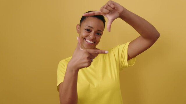 African american woman smiling confident doing photo gesture with hands over isolated yellow background