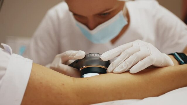 A dermatologist looks at a patient's skin.
