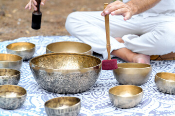 Close-up of man hands playing on a singing tibetian bowl with sticks. Sound healing music...