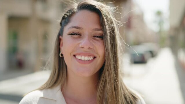 Young hispanic woman smiling confident standing at street