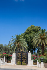 Fototapeta na wymiar Haifa, Israel, July 12, 2022 : The decorative metal gate at the entrance to the middle terrace of the Bahai Garden, located on Mount Carmel in the city of Haifa, in northern Israel