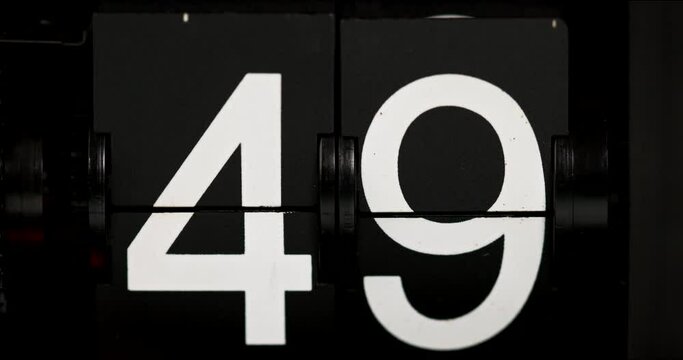Flip clock Vintage countdown white numbers forty-nine to fifty on black background.