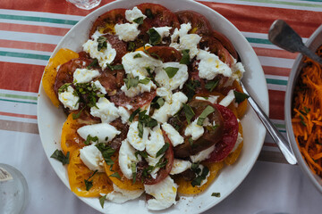 colorful tomatoes with mozzarella and basil served on a plate